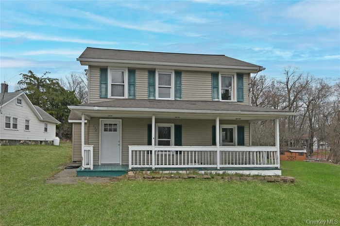 Farmhouse with a porch and a front lawn
