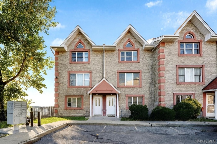 View of front of property featuring brick siding and uncovered parking