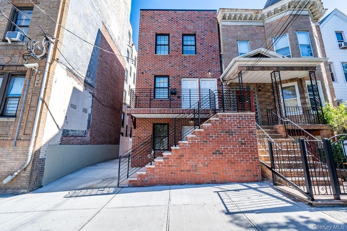 View of front of house with stairway and brick siding