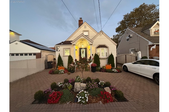 Bungalow featuring a gate, stucco siding, a chimney, decorative driveway, and a garage