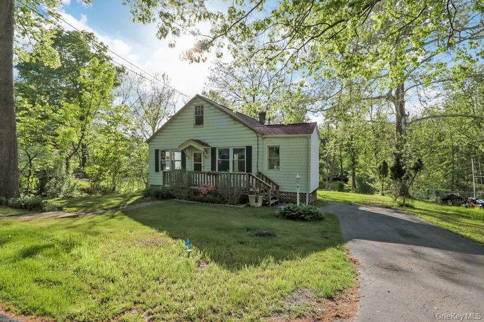 View of front facade featuring a front yard and driveway