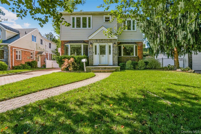 Colonial inspired home featuring brick siding