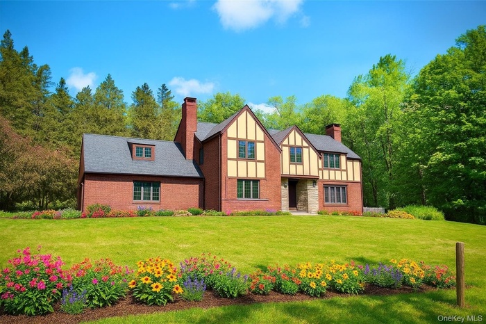 Tudor house with a chimney, board and batten siding, and a front yard