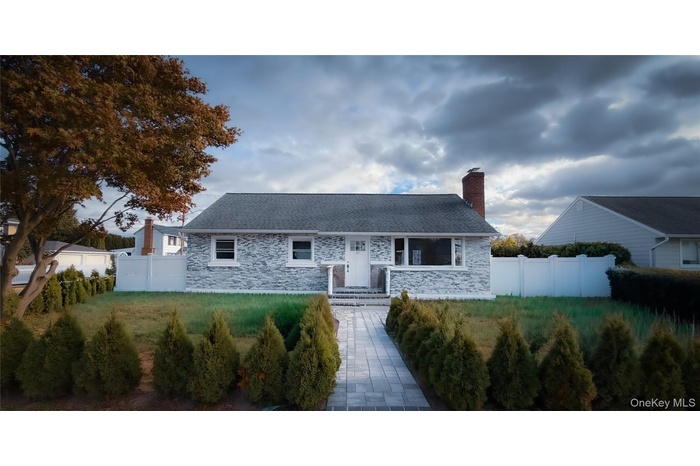 View of front of property with stone siding and a chimney