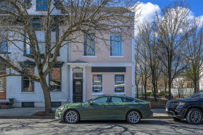 View of front of property featuring brick siding and fence