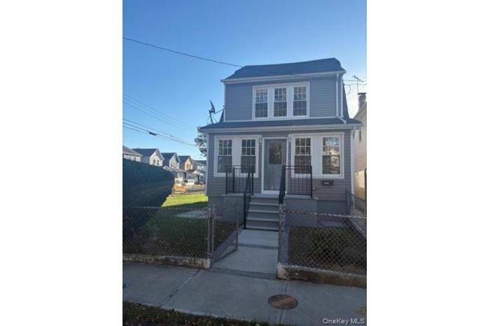 View of front facade with a fenced front yard and a gate