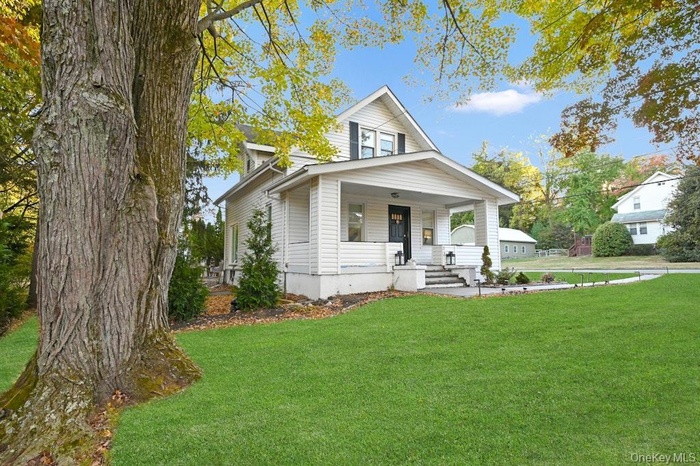 View of front of house featuring covered porch and a front yard