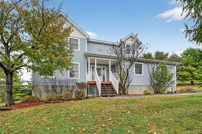 View of front facade featuring a front lawn and covered porch