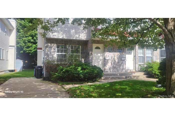 View of exterior entry with a yard and stone siding