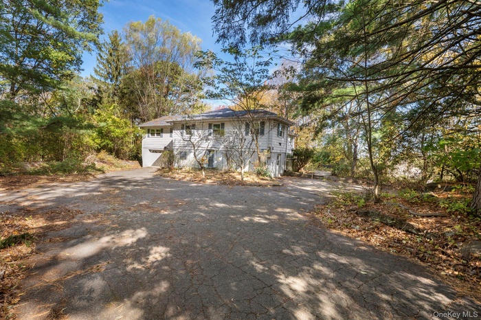 Welcome to 33 Albion Oval, a spacious Mahopac home with a circular driveway surrounded by mature trees and endless renovation potential.