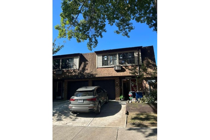 View of front facade featuring concrete driveway, brick siding, and an attached garage