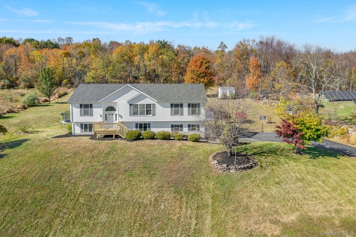 Rear view of property with a yard and a view of trees