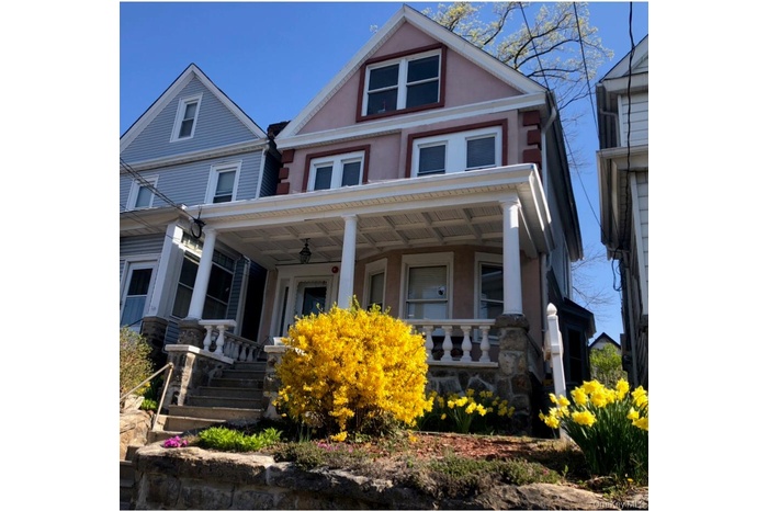 Victorian home with covered porch, stucco siding, and a ceiling fan