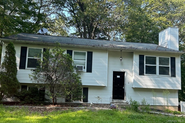 Split foyer home featuring a chimney