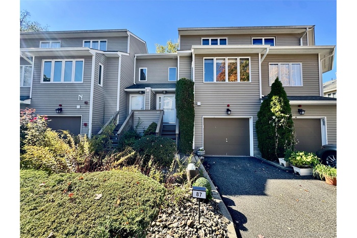View of front of home featuring asphalt driveway and an attached garage