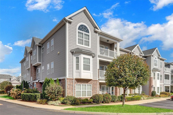 Traditional home featuring a residential view, stone siding, and uncovered parking