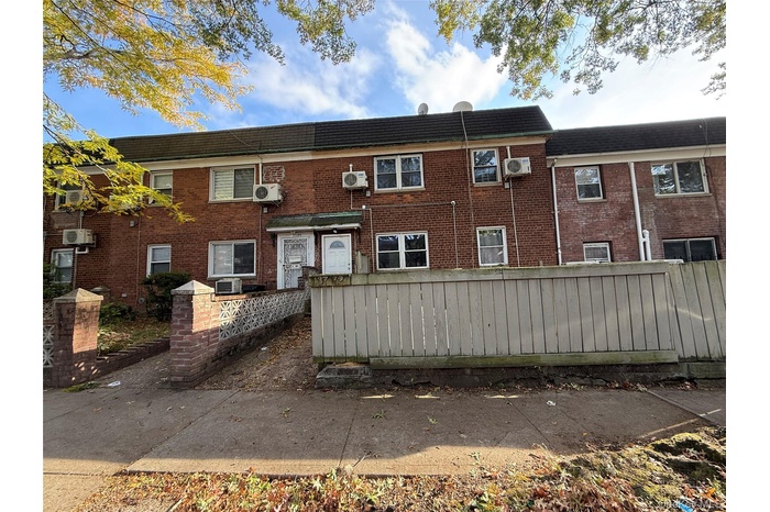 Traditional-style house with a fenced front yard and brick siding