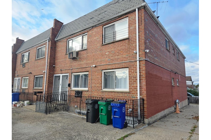 Rear view of property with brick siding and cooling unit
