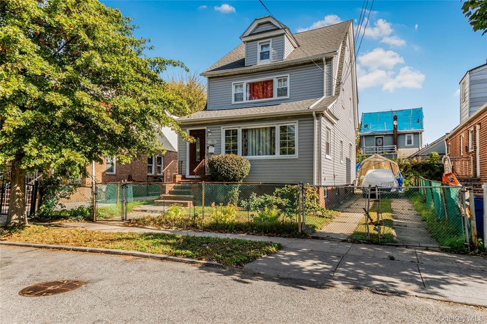 American foursquare style home featuring a gate, roof with shingles, and a fenced front yard