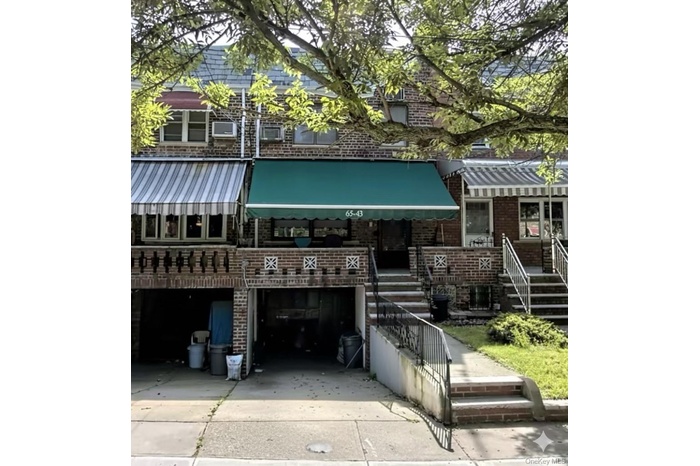 View of front of property featuring brick siding, concrete driveway, and an attached garage