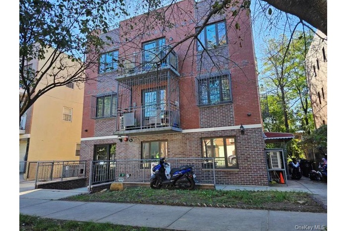 View of front of house featuring brick siding and a balcony