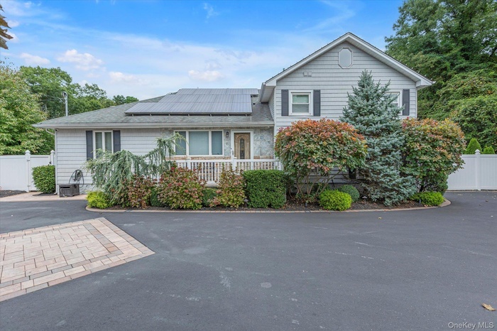 Split level home with solar panels and covered porch