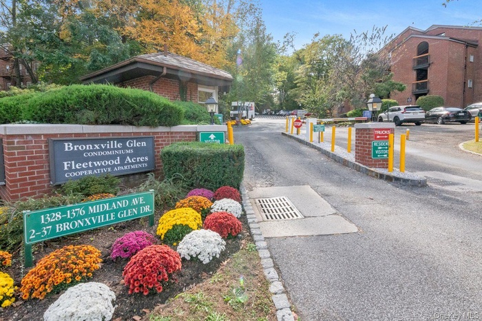 View of asphalt street with curbs and a gated entry