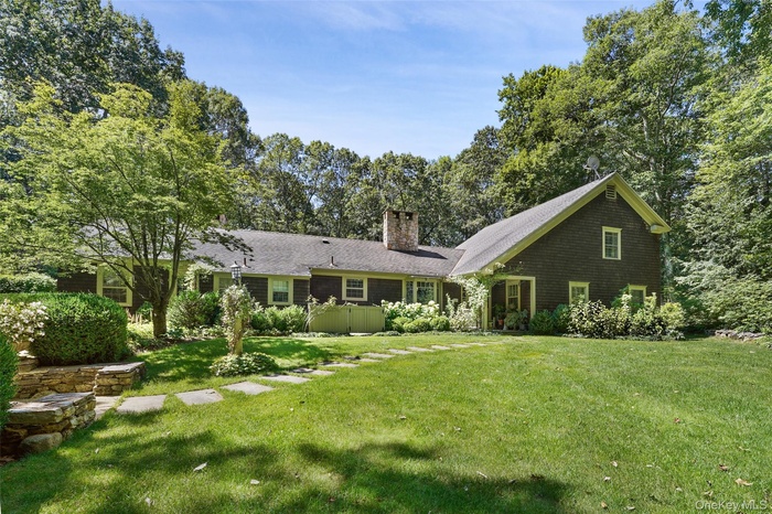 Back of property featuring a lawn and a chimney
