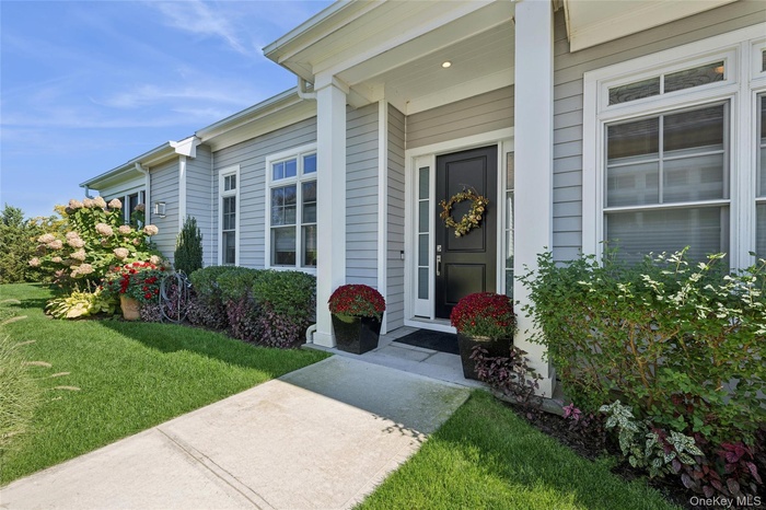 Doorway to property featuring a lawn