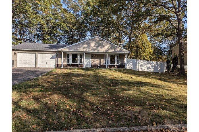 View of front of house featuring a porch, asphalt driveway, an attached garage, and brick siding
