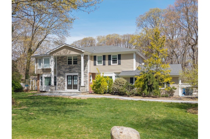 Split foyer home featuring stone siding, a front yard, and french doors