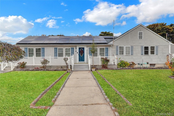 View of front of home with a front lawn and solar panels