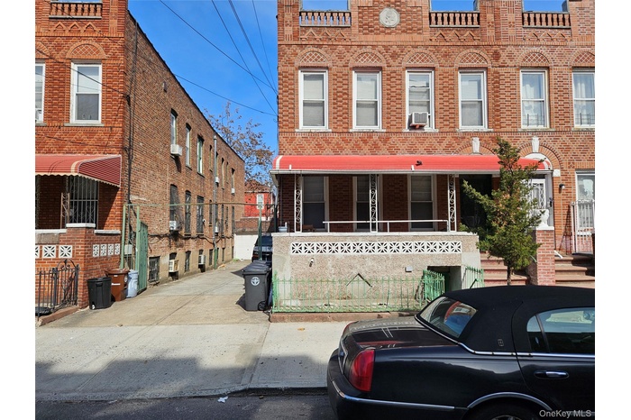 View of property featuring brick siding, covered porch, and cooling unit