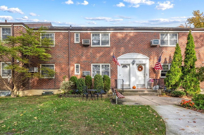 View of front of property featuring brick siding and a front lawn