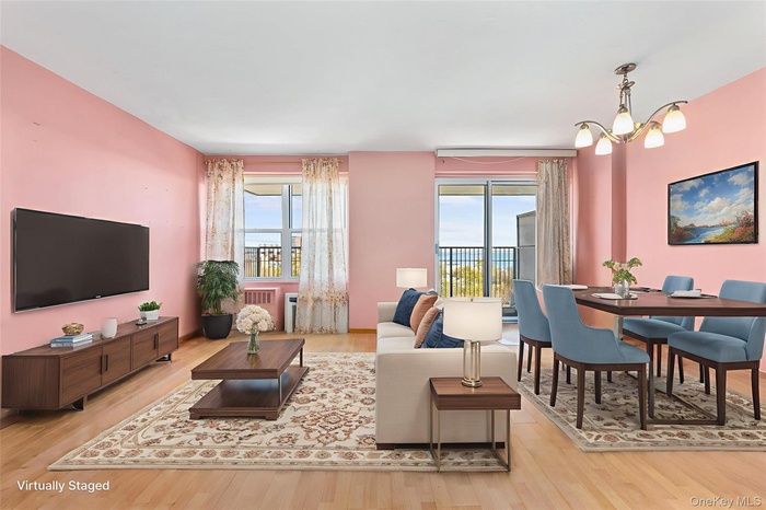 Living area featuring light wood finished floors, healthy amount of natural light, and a chandelier