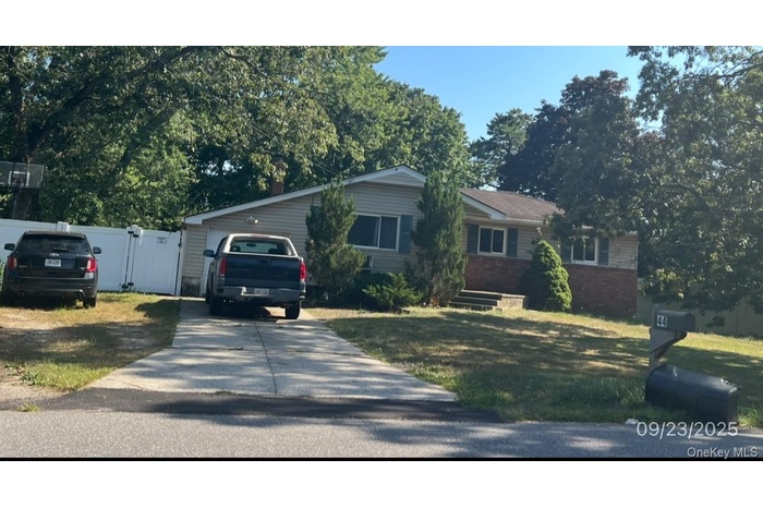 Ranch-style home with concrete driveway, brick siding, a garage, and a front lawn