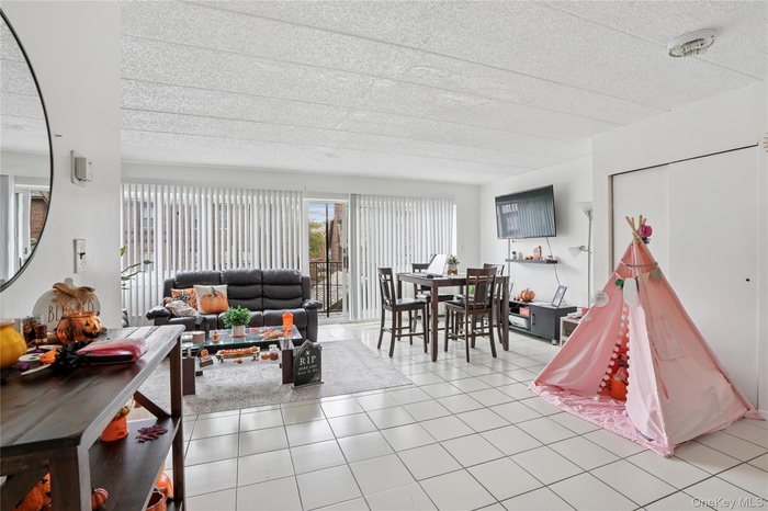 Living room with light tile patterned floors and a textured ceiling