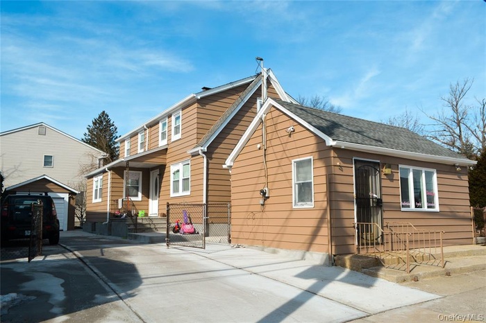 Rear view of property with an outbuilding and driveway