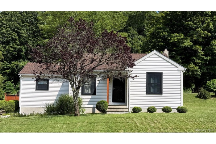 View of front of home featuring a front yard and roof with shingles