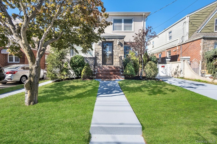 View of front facade featuring stone siding and a front yard