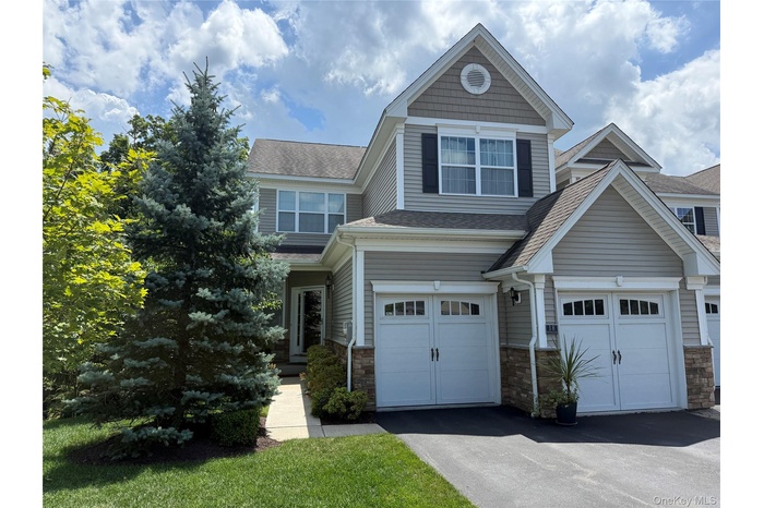 Craftsman inspired home with roof with shingles, stone siding, driveway, and a garage