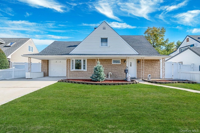 View of front facade featuring roof with shingles, stone siding, driveway, and an attached garage
