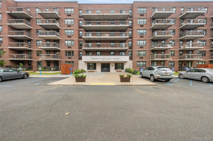 View of apartment building / complex with uncovered parking