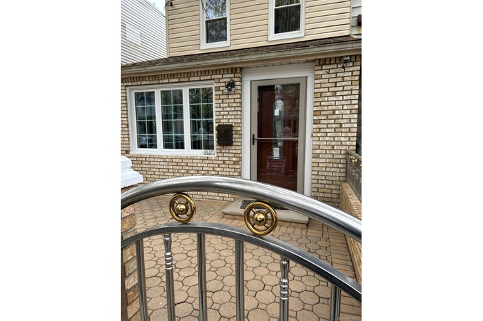 Property entrance featuring brick siding and a gate