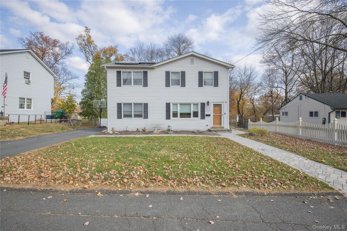 Traditional-style house featuring asphalt driveway and roof mounted solar panels