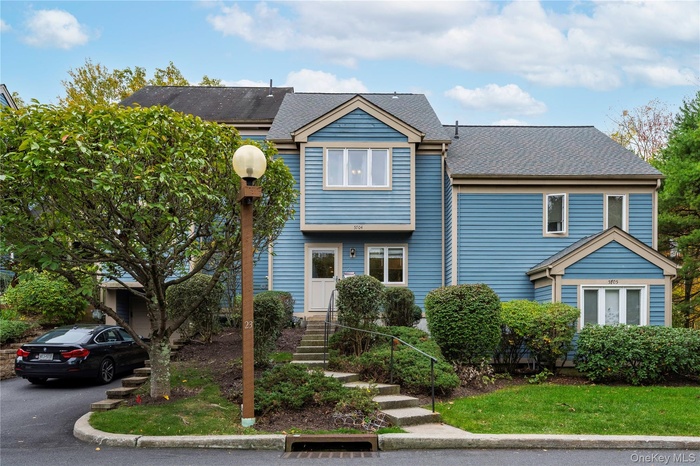 View of front of property with roof with shingles and a front yard
