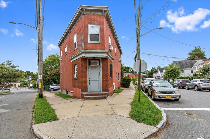 View of front facade with brick siding and uncovered parking