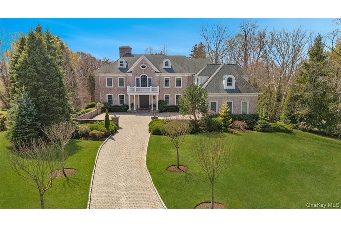 Grand entrance down a long driveway bordered by decorative flowering trees to enclosed courtyard...
