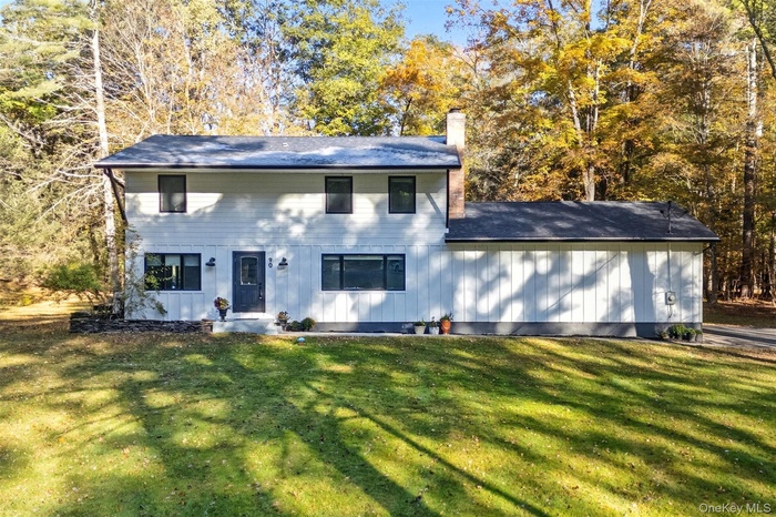 View of front of house with a chimney and a front yard