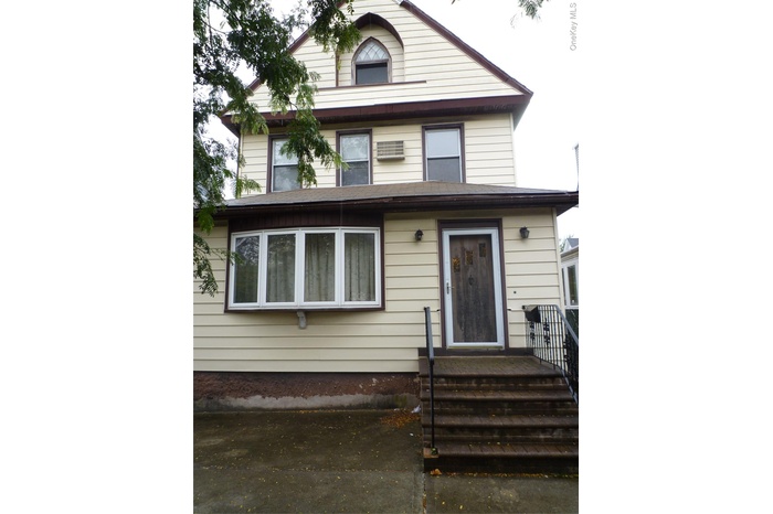 View of front of home featuring an AC wall unit